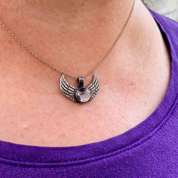 silver angel wings glass cremation jewelry on model